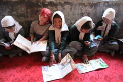 Children at Youl Turtuk Government Primary School excitedly read their new books.